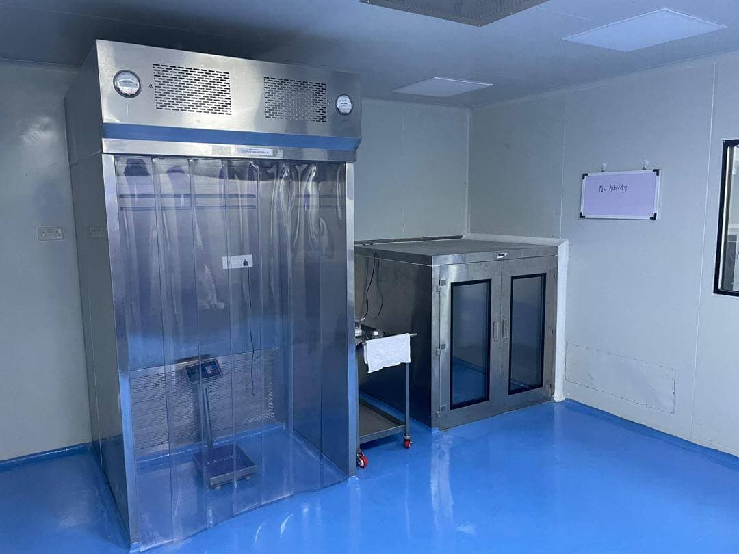 Dispensing booth and pass-through chamber in a controlled production area