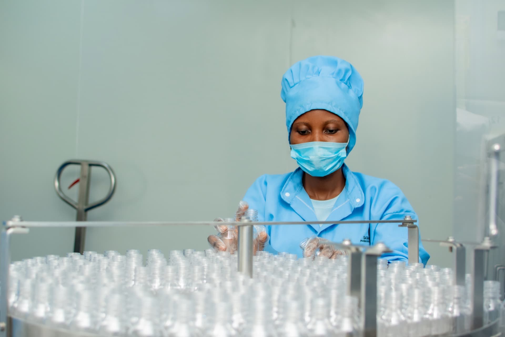 Team member inspecting bottles on a circular production line