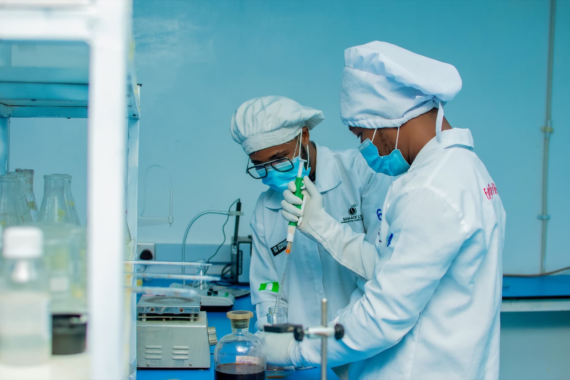 Sam-Ace laboratory technicians preparing samples with a pipette
